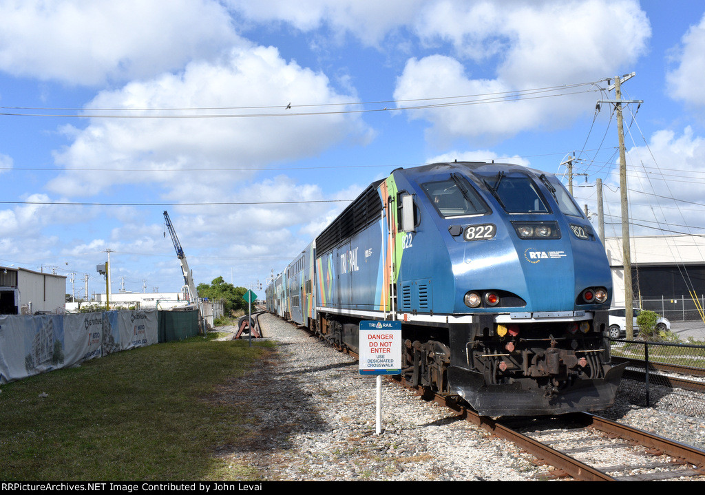 A southbound Magonia Park to Miami Airport Tri-Rail Train arrives into Metrorail Transfer Station behind BL36PH # 822 